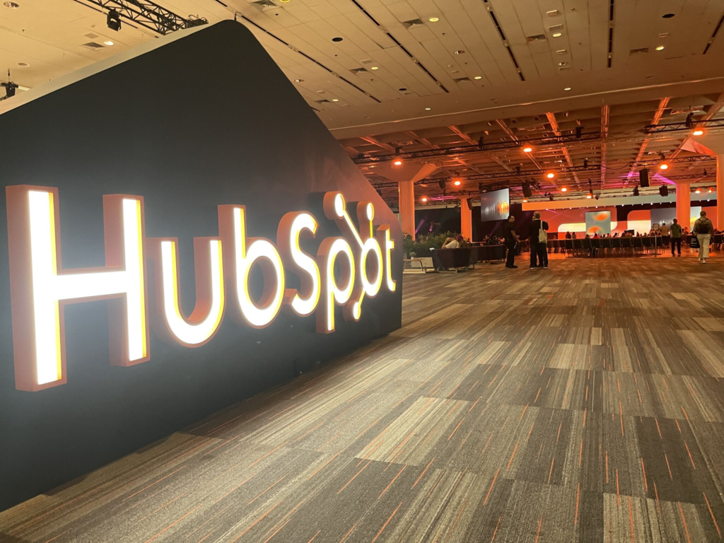 A large illuminated HubSpot sign standing in an empty event hall