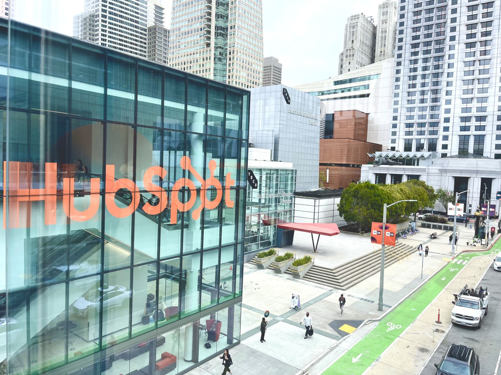 A HubSpot logo on a glass building overlooking a city plaza